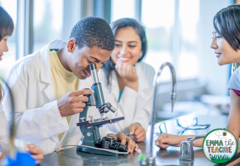 An image of a group of students working on a biology lab, which involves looking into a microscope.