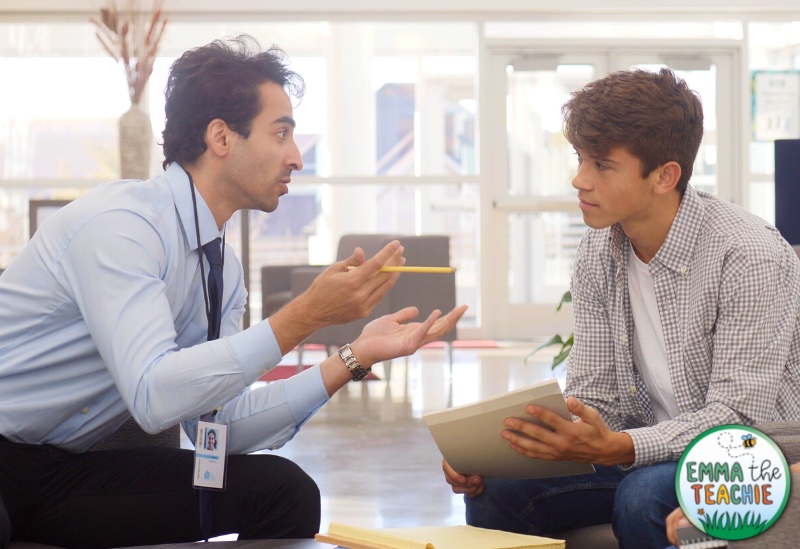 A male teacher is building a good relationship with their student by discussing the behavior policy with the student. 