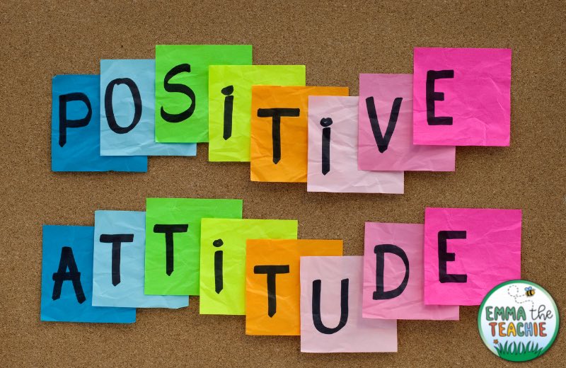 A corkboard with a variety of colored sticky notes. Each sticky note has an individual letter. The letters spell “positive attitude.”