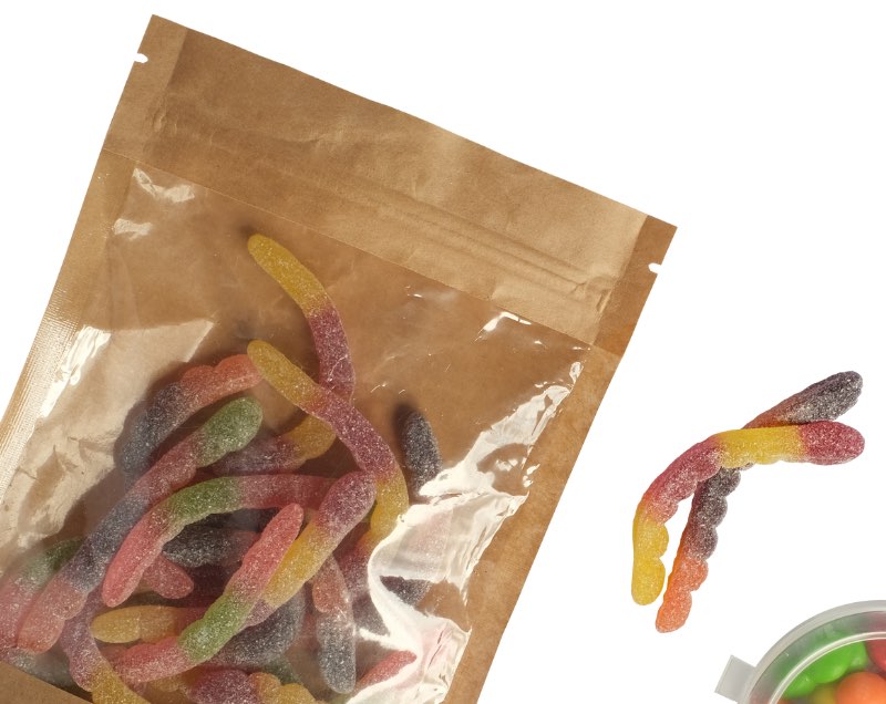 A bag of gummy worms to the left of the image. On the right, there are two gummy worms joined together like a chromosome.
