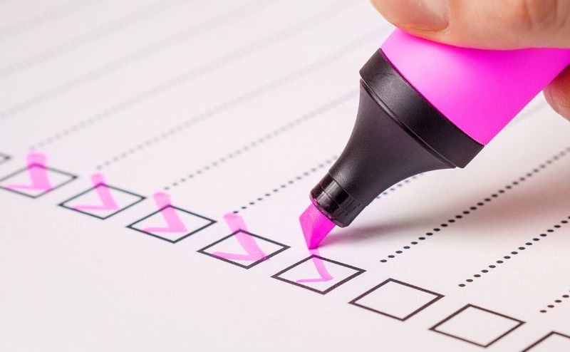 An image of a checklist and pink highlighter checking off the boxes.