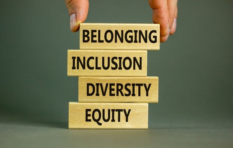 A stack of blocks against a green background. From top to bottom, the blocks read” Belonging, Inclusion, Diversity, and Equity.