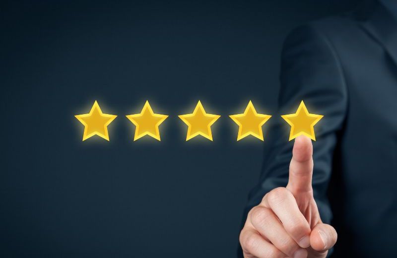 An image showing a hand pointing to 5 filled out stars, indicating a 5-star review.