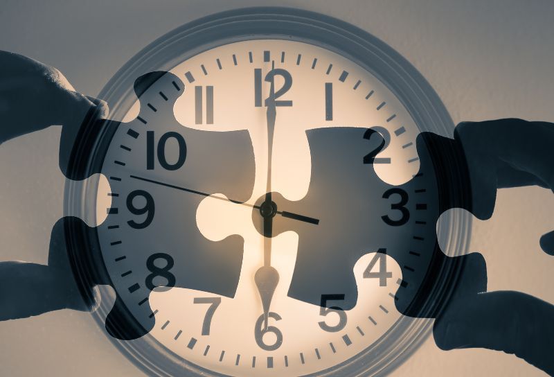A clock with the shadow of two hands connecting two puzzles over the clock, indicating that figuring out time is like a puzzle